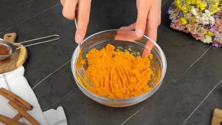 mashing the dweet potato in a clear bowl