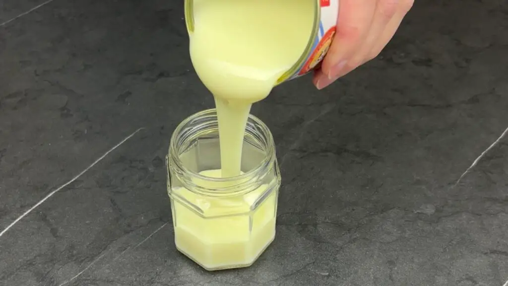 pouring condensed milk into glass jar