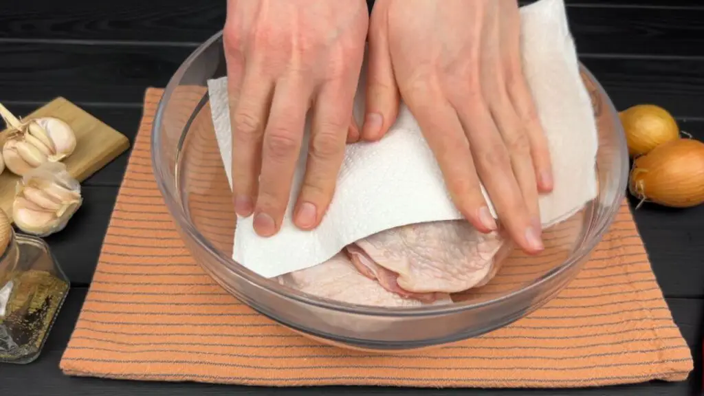 Patting chicken thighs dry before cooking them