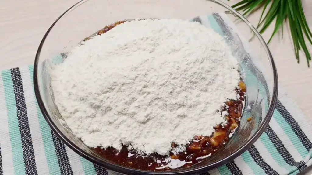 adding the dry ingredients of old fashioned date cake recipe