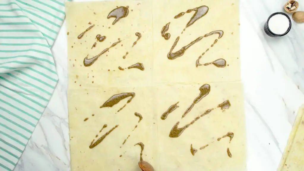 Baklava phyllo sheets with tahini spread evenly over the surface for an easy baklava recipe