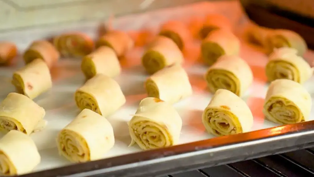 Baklava rolls spaced apart on a baking sheet so they bake evenly and stay crisp, an easy baklava hack
