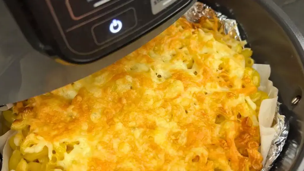 Cheesy pasta bake with a golden, melted top cooking in an air fryer