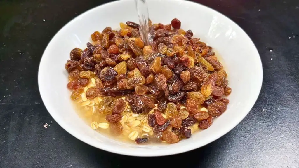 Hot water poured over rolled oats and raisins to soak for a banana oats