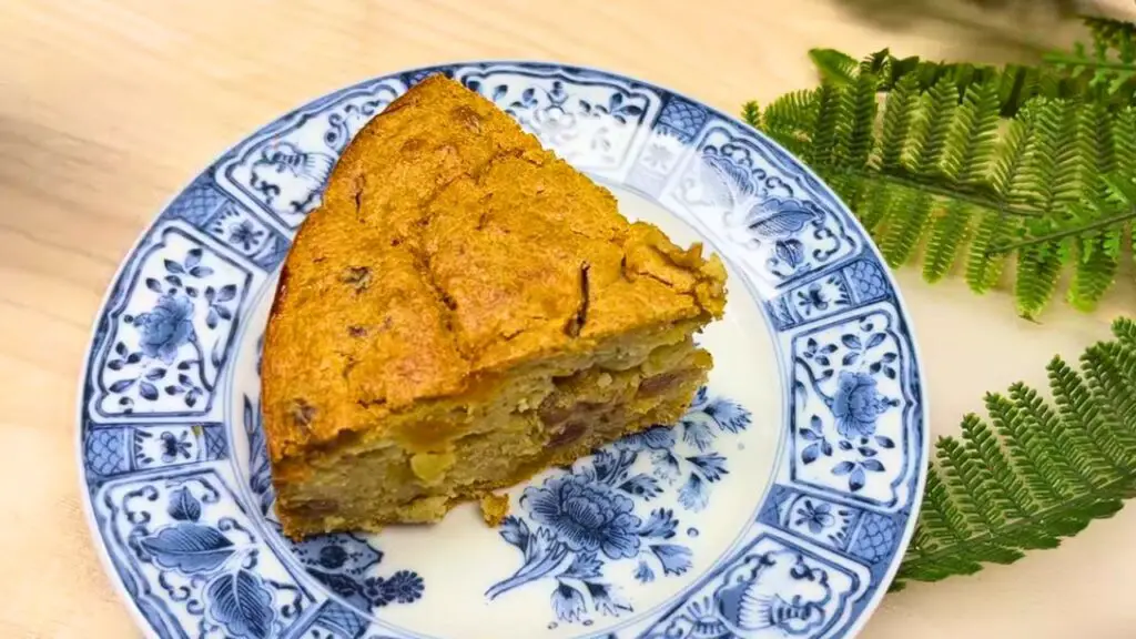 Slice of healthy oatmeal apple and carrot cake on a patterned plate.