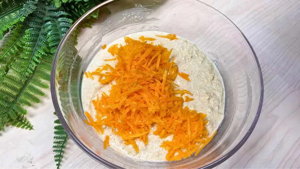 adding grated carrot to the healthy oat cake batter