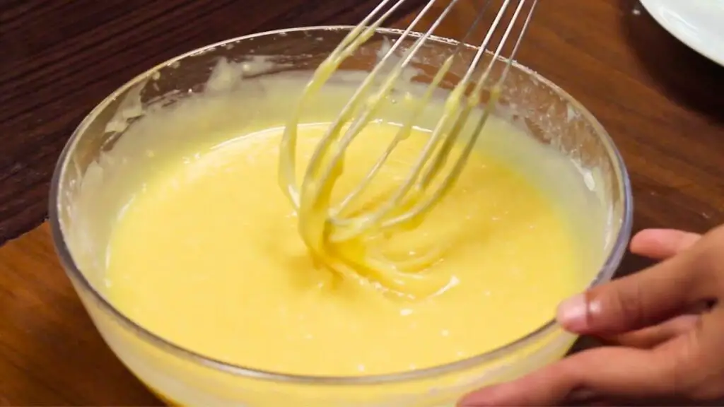 Whisk lifting smooth lemon brownie batter at the perfect consistency for the best lemon brownies recipe, showing the right texture after mixing just until combined and not overmixing.