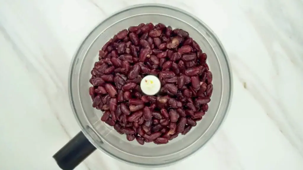 a food processor bowl filled with rinsed black beans for black bean brownies batter preparation
