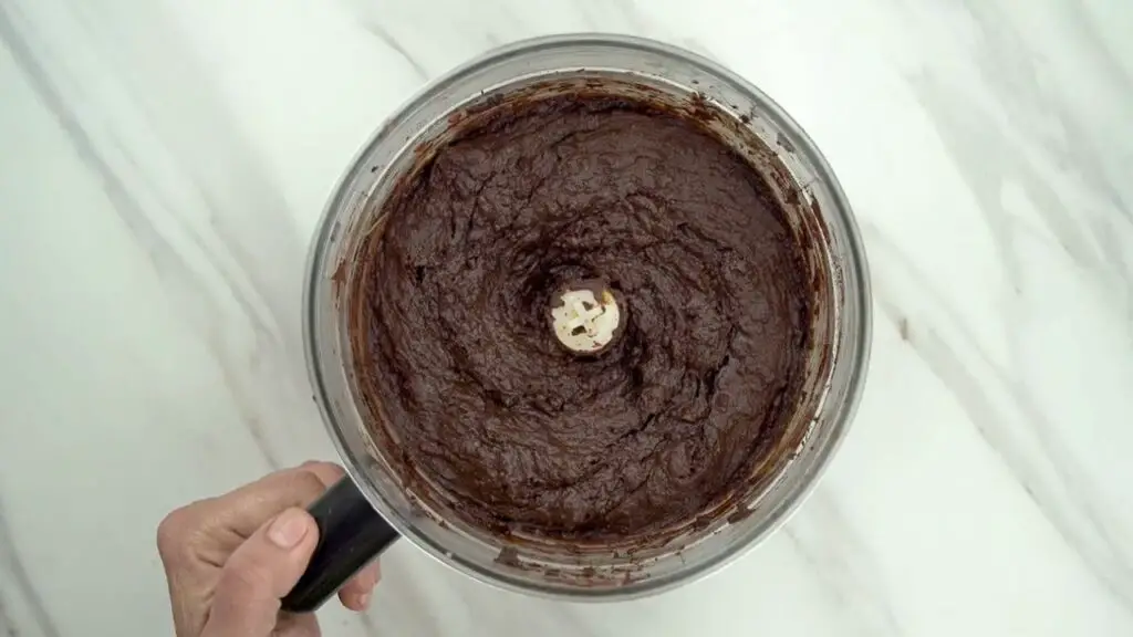 food processor filled with thick, smooth chocolate batter for bean brownies