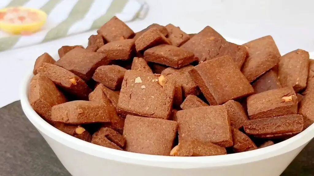 A bowl filled with crisp, bite-sized chocolate cereal squares is shown ready for storage as healthy chocolate cereal.