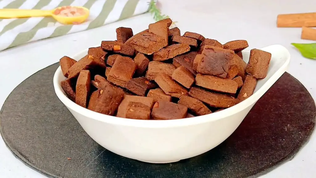 A bowl filled with crunchy chocolate bite-sized pieces is served as homemade cereal, ready for snacking or breakfast.