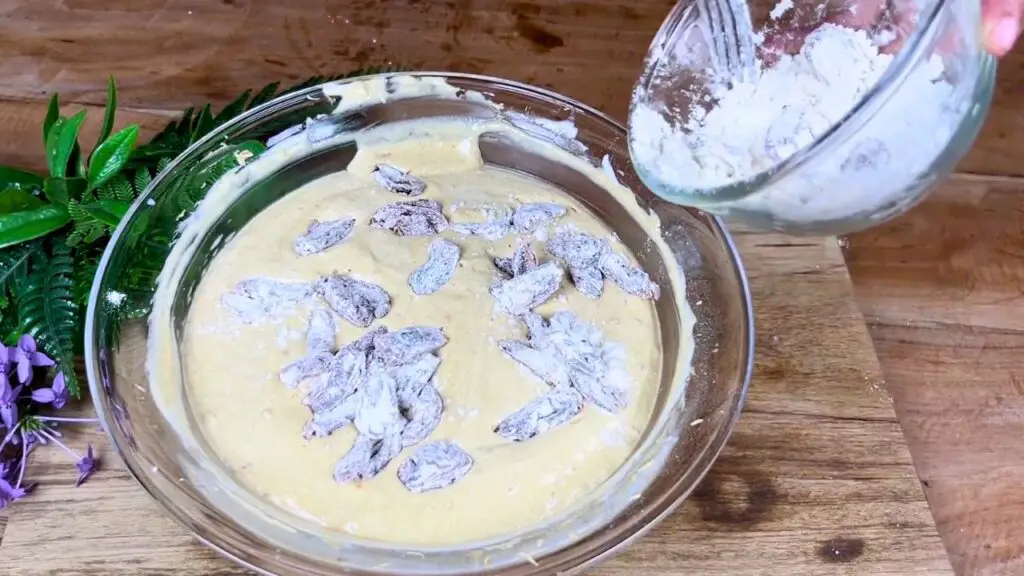 Flour-coated chopped dates are being added to smooth cake batter and gently mixed until evenly distributed in this simple moist date cake recipe.