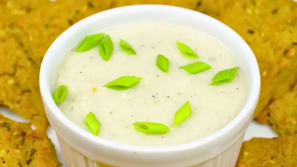 creamy dip topped with sliced green onions, served alongside baked crackers in this savory crackers recipe.