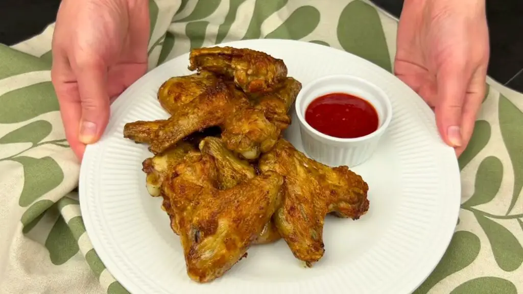 Air fryer chicken wings served on a plate with dipping sauce, perfect for easy serving ideas.