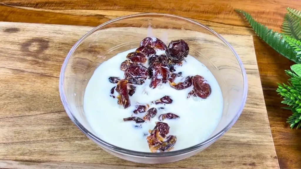 Dates soaking in hot milk to soften for the sticky date cake recipe, making them easier to blend into a smooth mixture.