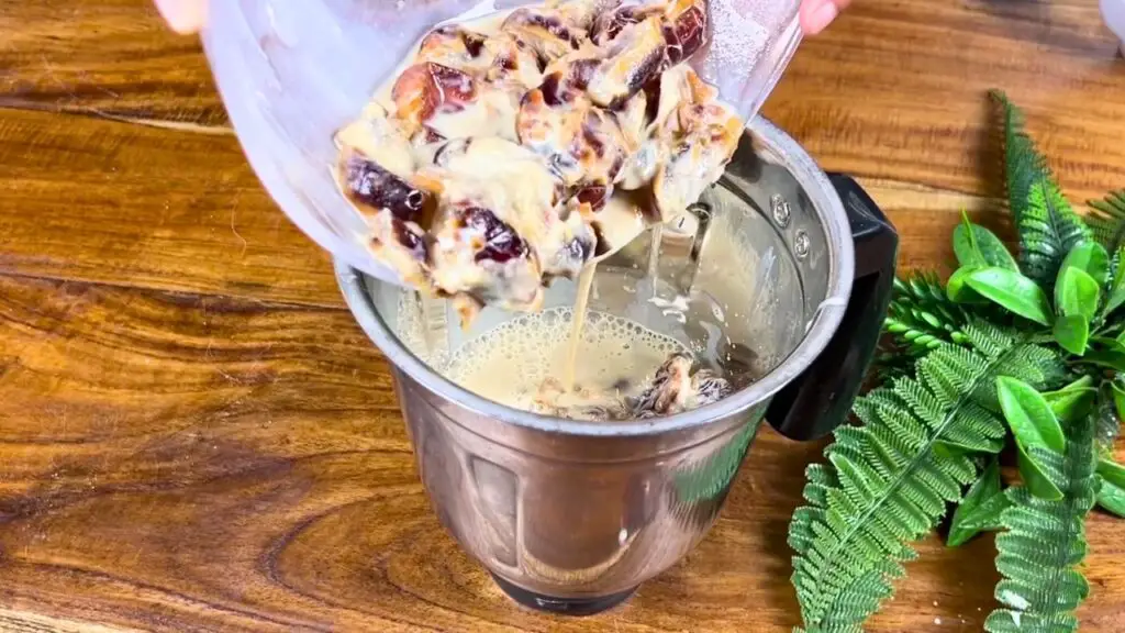 Soaked dates and milk being added to a blender to make a smooth and creamy mixture for the sugar free date cake recipe.