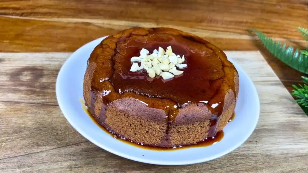 Sticky date cake recipe topped with glossy date syrup and chopped walnuts, ready to serve warm as a rich and moist des