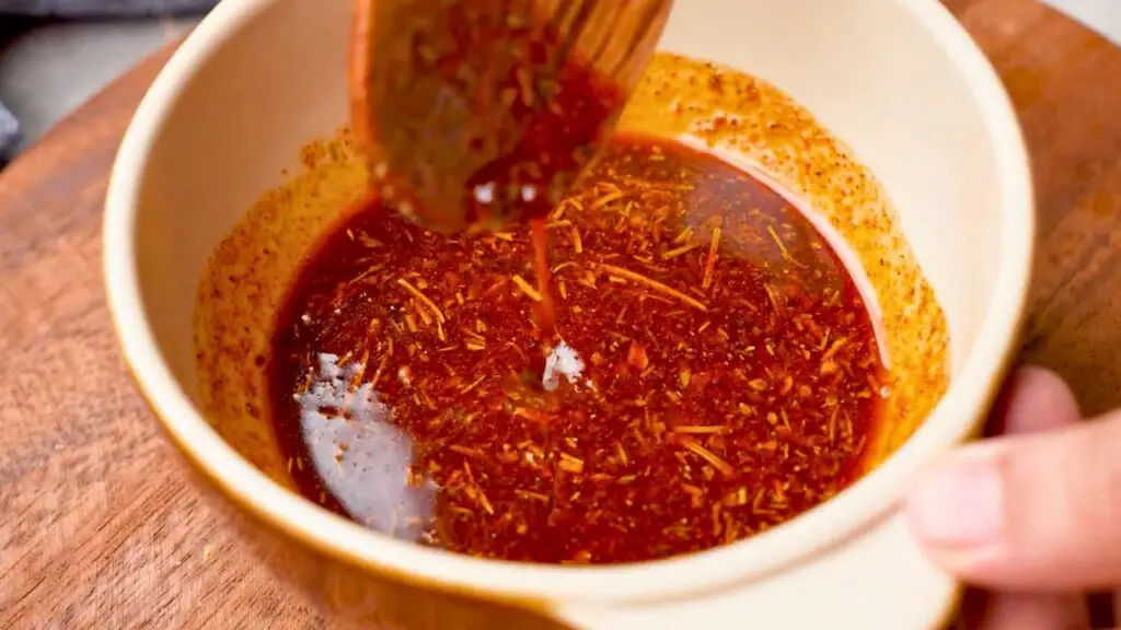 Bowl of homemade chicken seasoning and marinade with paprika, herbs, and spices mixed together, ready to use for easy seasoning swaps on air fryer whole chicken.