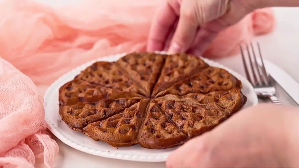 Crispy lentil waffles sliced into wedges on a white plate, ready to serve and reheat for a quick breakfast.