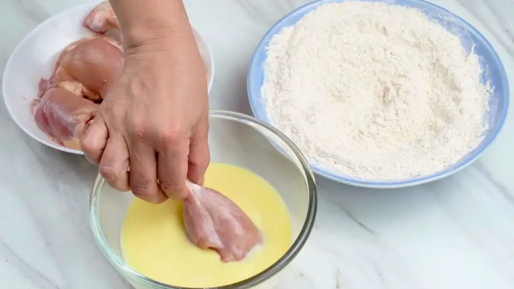 Dipping chicken into the buttermilk mixture for an air fryer fried chicken recipe.