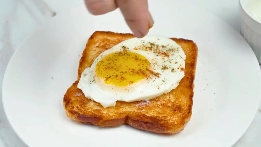 Air fryer poached egg on toast seasoned with black pepper and paprika, ready to serve for breakfast.