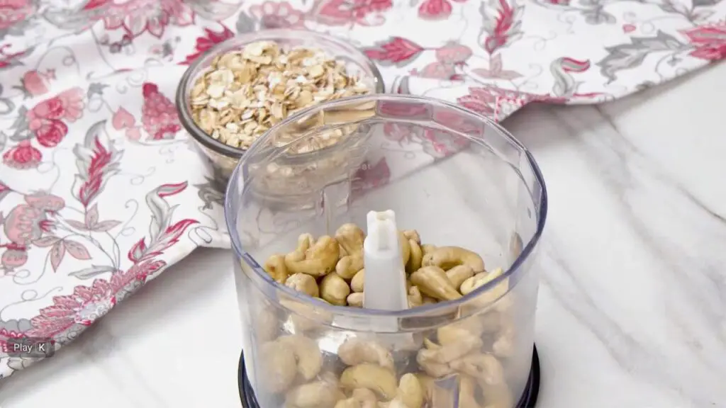 Cashews being blended in a food processor to make a creamy base for a healthy oat ice cream recipe.