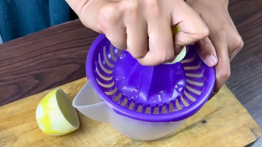 Fresh lemon being squeezed with a citrus juicer to make lemon juice for a Starbucks-style lemon loaf cake.