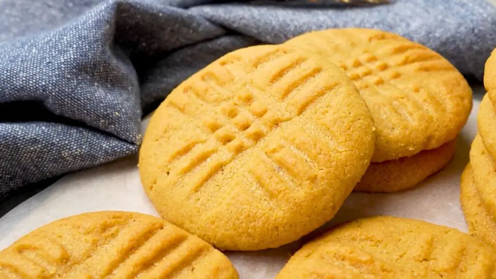 Golden air fryer cookies with classic peanut butter criss-cross fork marks cooling on parchment paper.