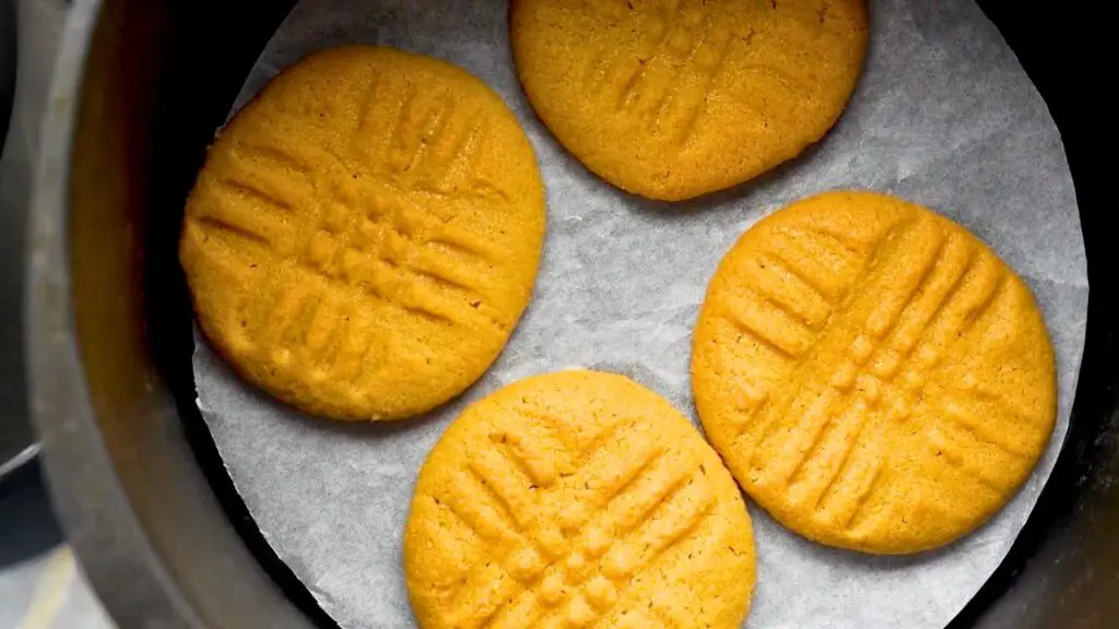 Golden air fryer peanut butter cookies reheating inside an air fryer basket.