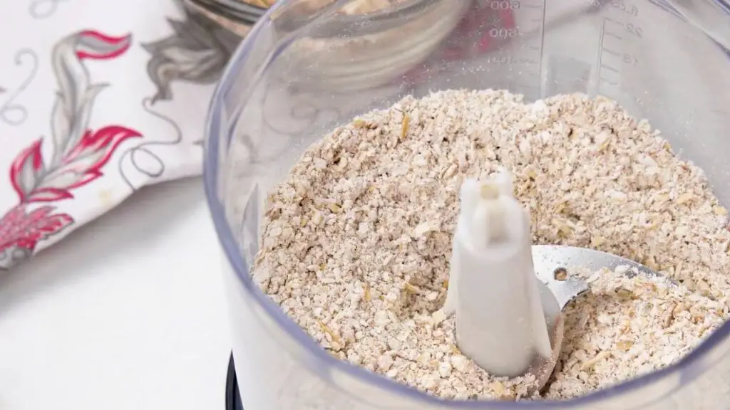 Healthy oat ice cream recipe with rolled oats blended into fine oat flour in a food processor before mixing the creamy ice cream base.
