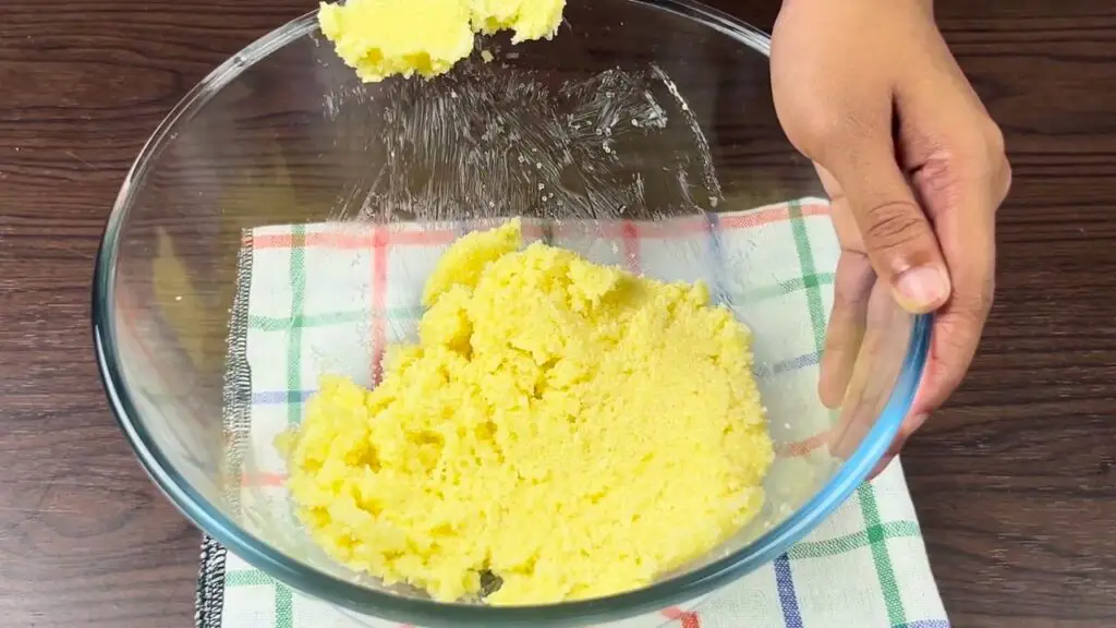 Soft butter being mixed with lemon sugar in a glass bowl to make a Starbucks-style lemon loaf batter.