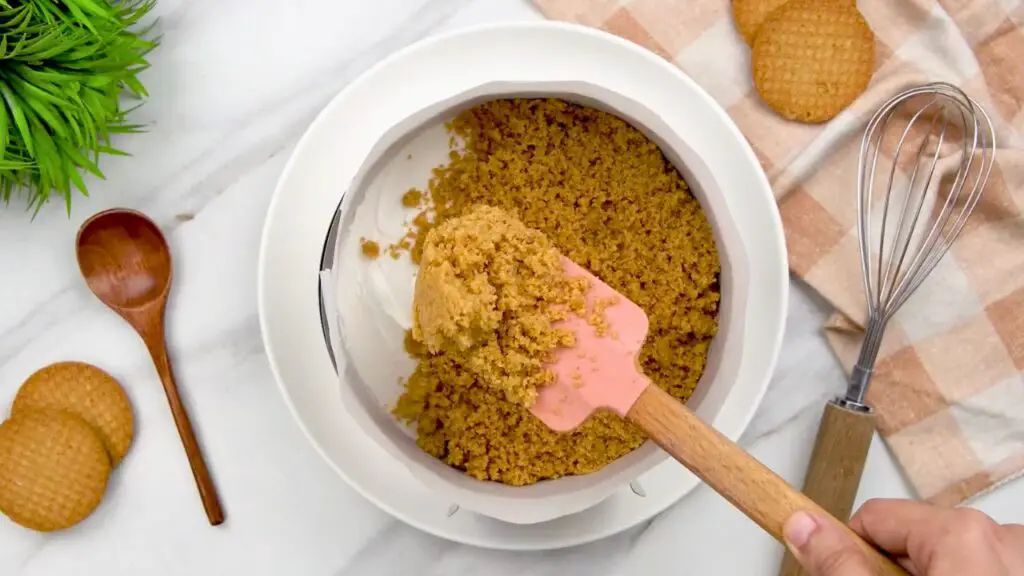 Adding the middle biscuit crust to a cheesecake with extra crust.
