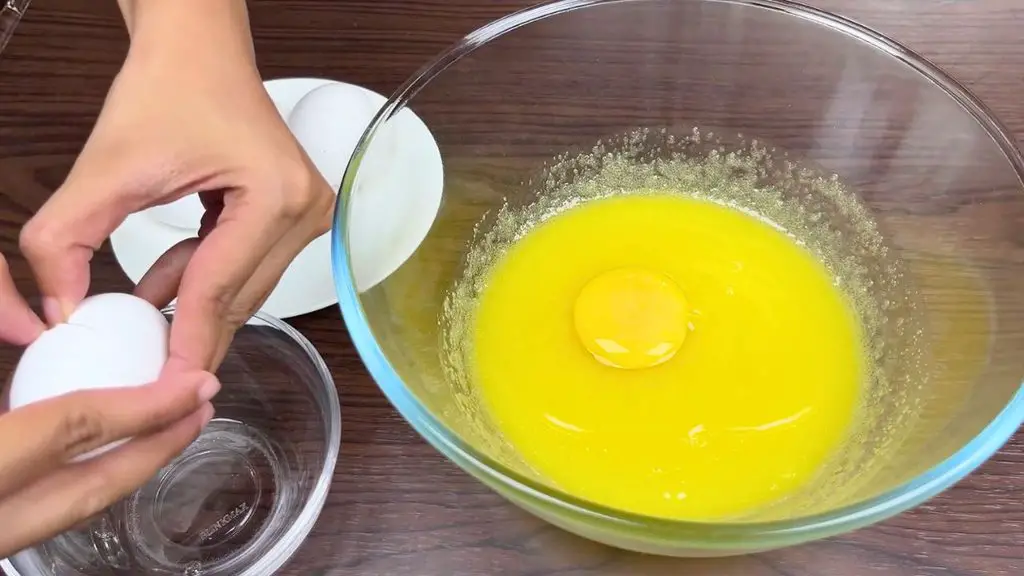 Brownies with shiny crust recipe showing eggs being added to the brownie batter.