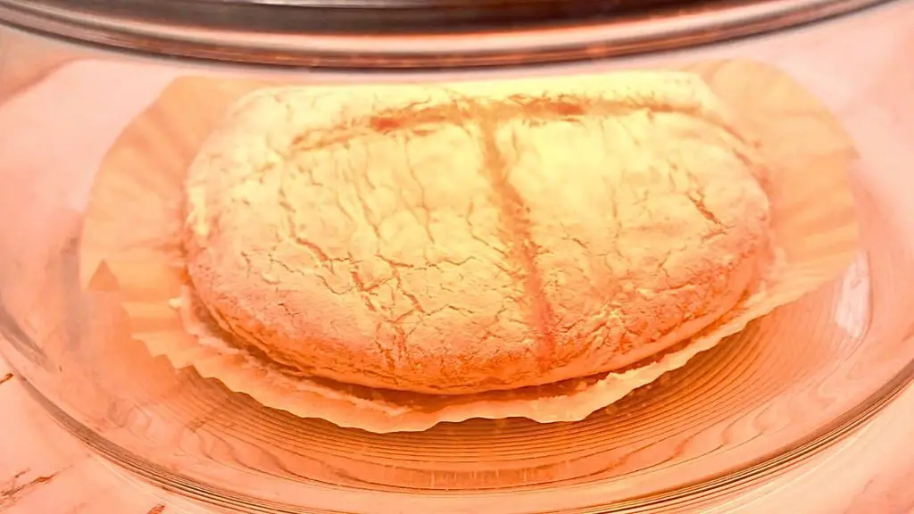 Air fryer bread baking in a glass bowl air fryer, showing the loaf rising and browning during cooking.
