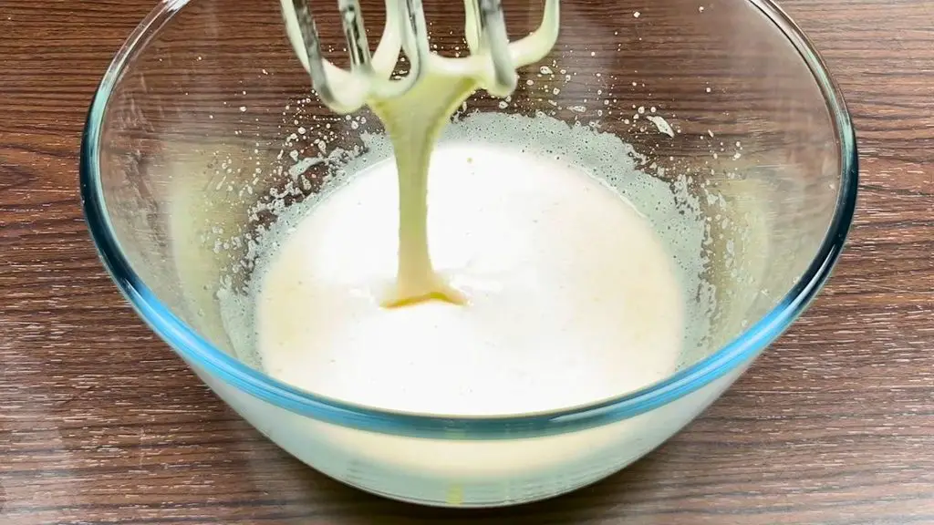 Pale and creamy egg and sugar mixture beaten with an electric mixer for lemon cake.