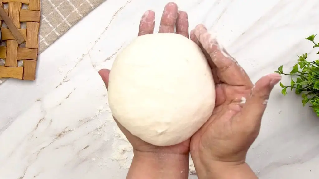 Shaping the dough into a smooth round loaf for this easy no-knead air fryer bread.