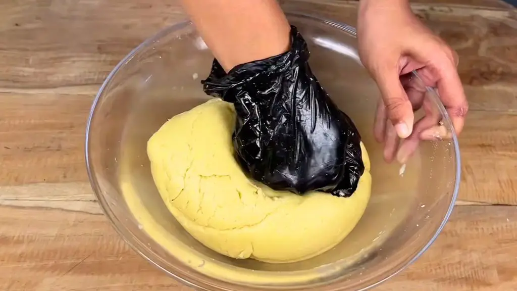 Mixing classic shortbread dough by hand in a glass bowl until it forms a soft ball.