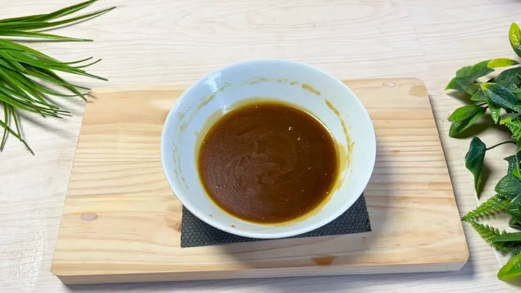 Smooth, glossy brown toffee sauce in a white bowl, ready to pour over a warm caramel toffee apple cake.