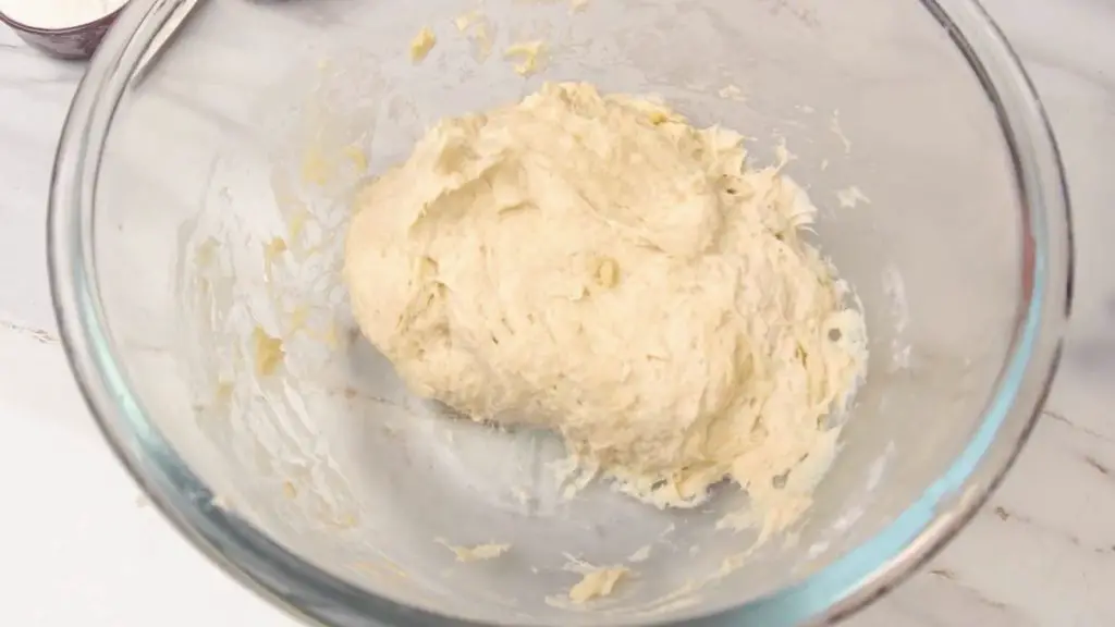 Soft, slightly sticky dough mixed with flour and olive oil in a glass bowl for air fryer milk bread.